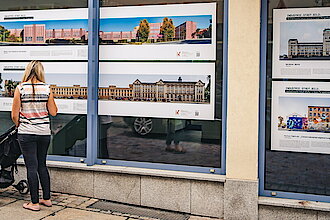 Eine Frau mit Kinderwagen steht in Reichenbach vor einem Schaufenster der Ausstellung (Foto: Oliver Göhler)